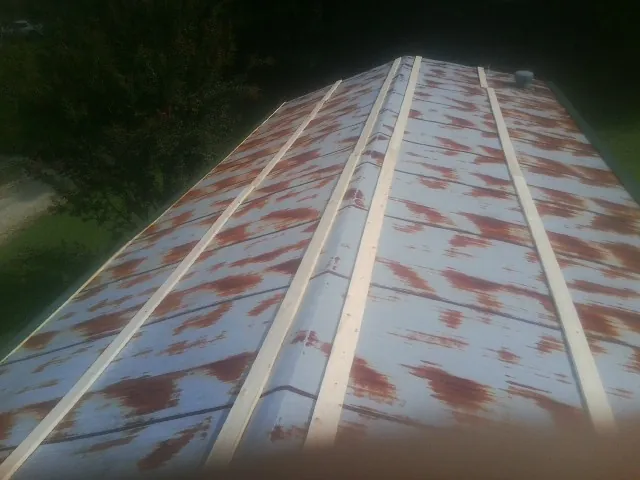Rusted metal roof panels with new wood purlins before replacement — Storm Damage Roof Repair in Connoquenessing by Roofing Brothers