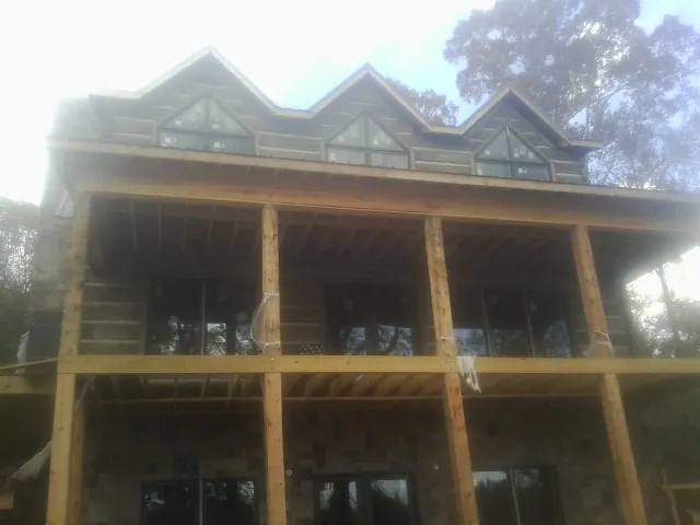 Dormers and porch framing on a large log home under construction — Roof Coating work by our crew in Connoquenessing