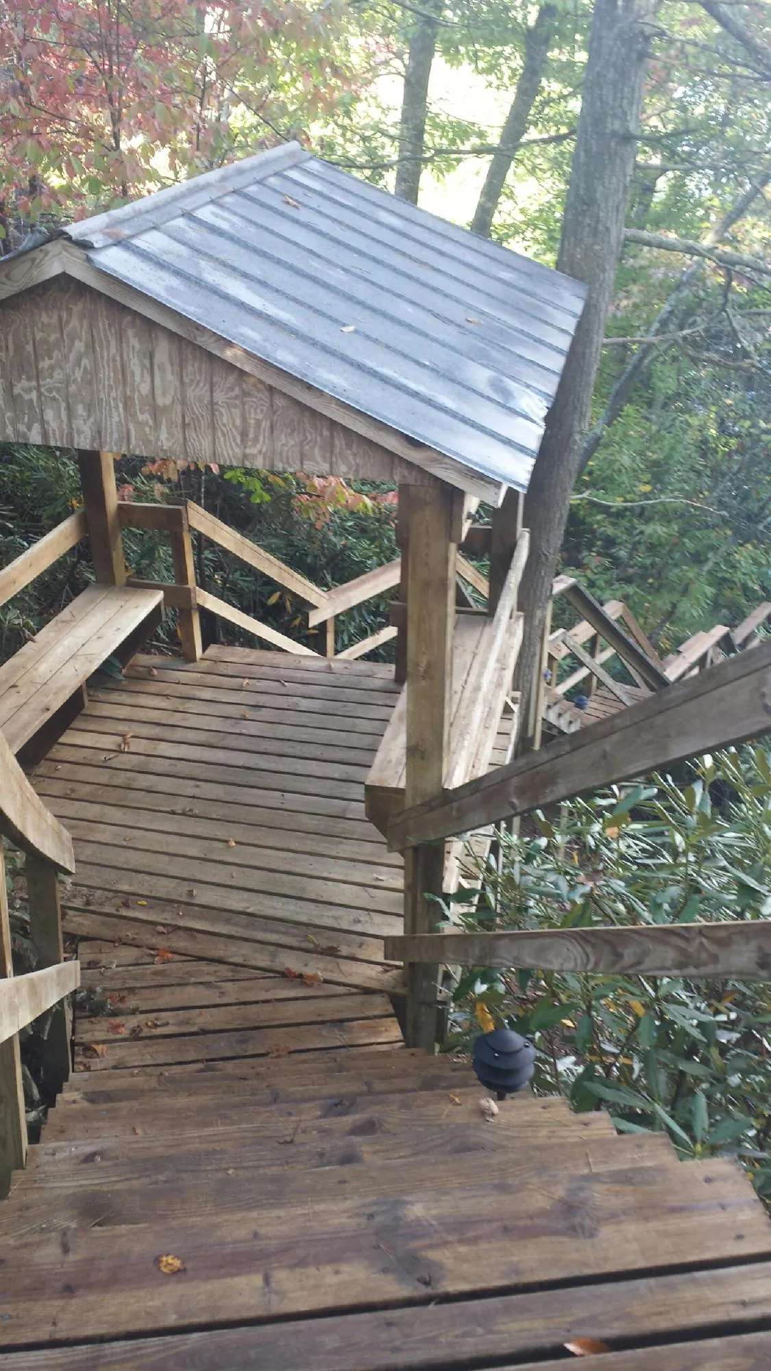 Metal roofed shelter over wooden steps on a wooded walkway — Skylight Repair & Installation work by our crew in Connoquenessing