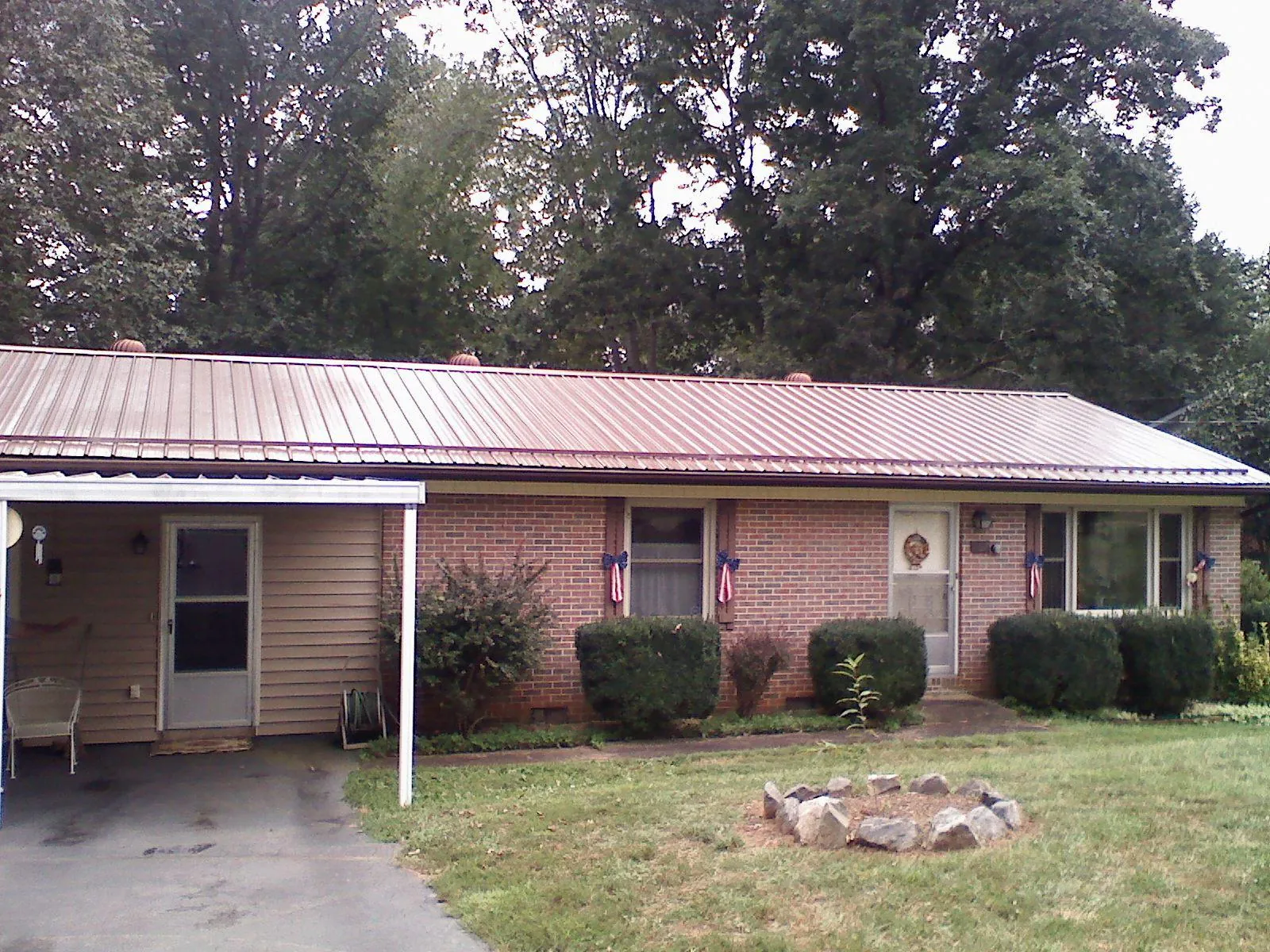 Bronze metal roof and carport on a brick ranch home — Roof Repair work by our crew in Connoquenessing